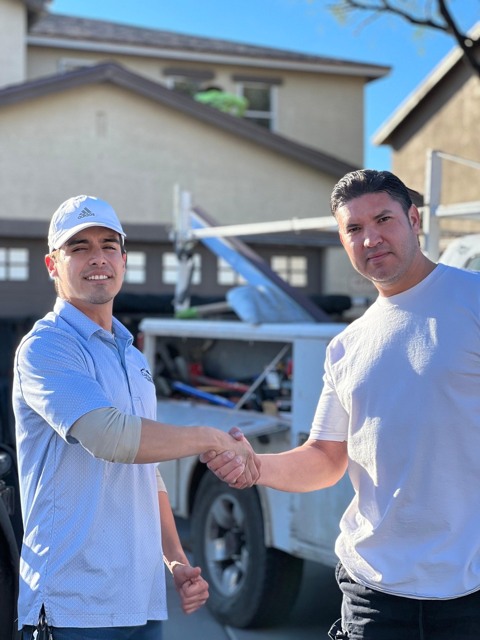 David from Camelback Roofing shaking hands with a customer in front of the work truck